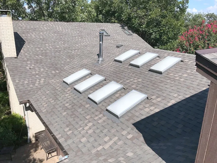 A shingle roof with a row of skylights