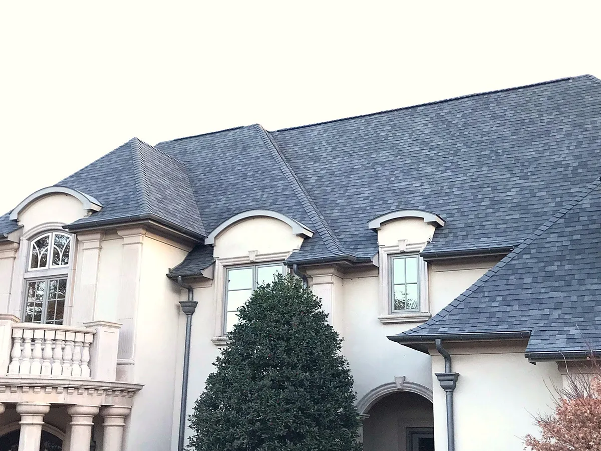 A white stucco home with a new gray shingle roof